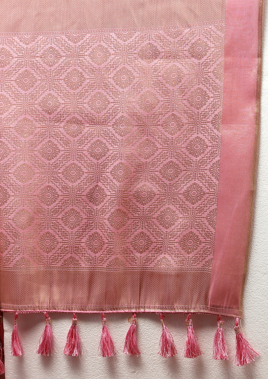 Traditional pink saree with delicate zari detailing and tassels at the pallu, ideal for cultural gatherings.