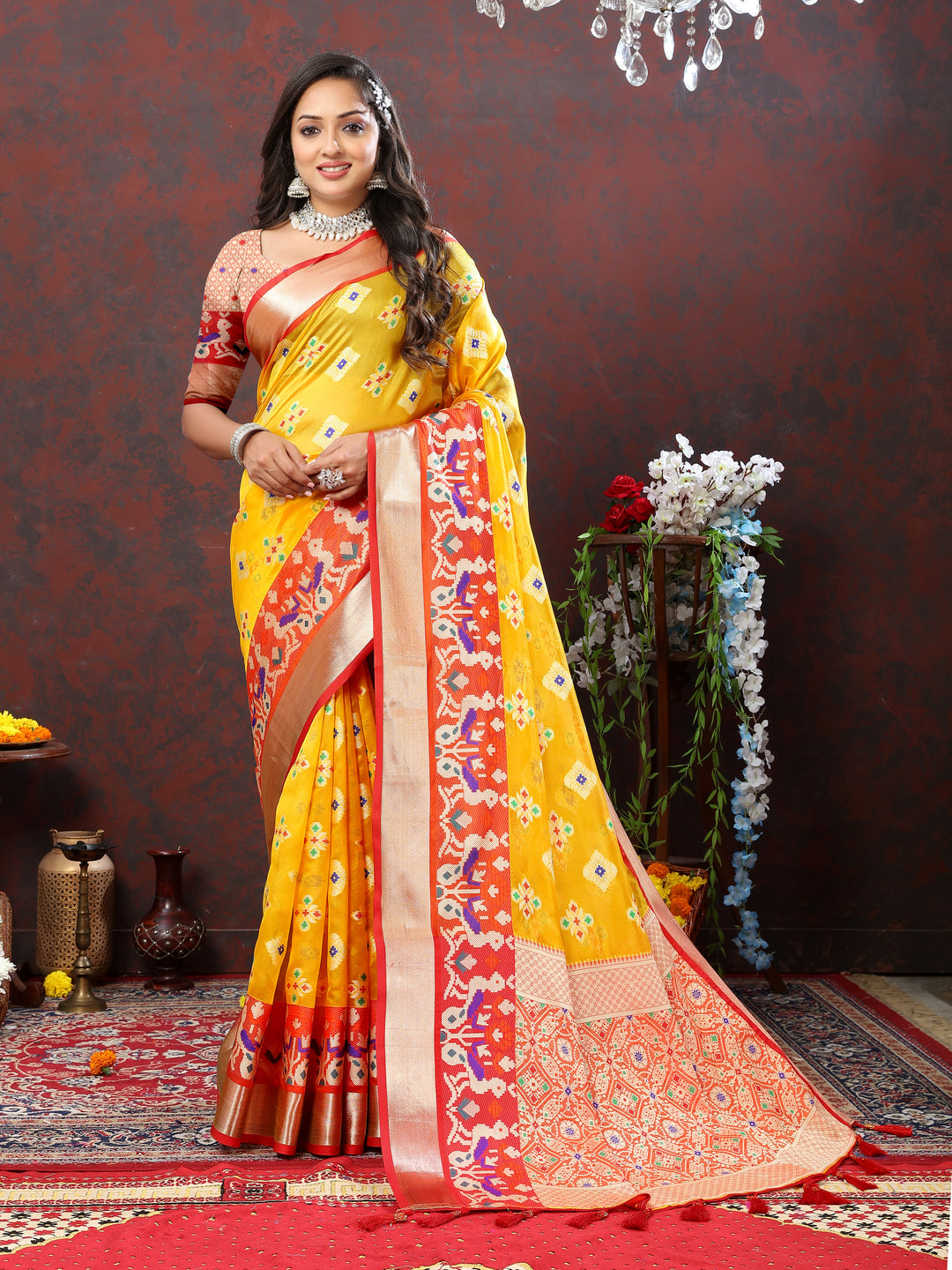 Yellow silk saree with Meenakari design and tassel detailing on the pallu.