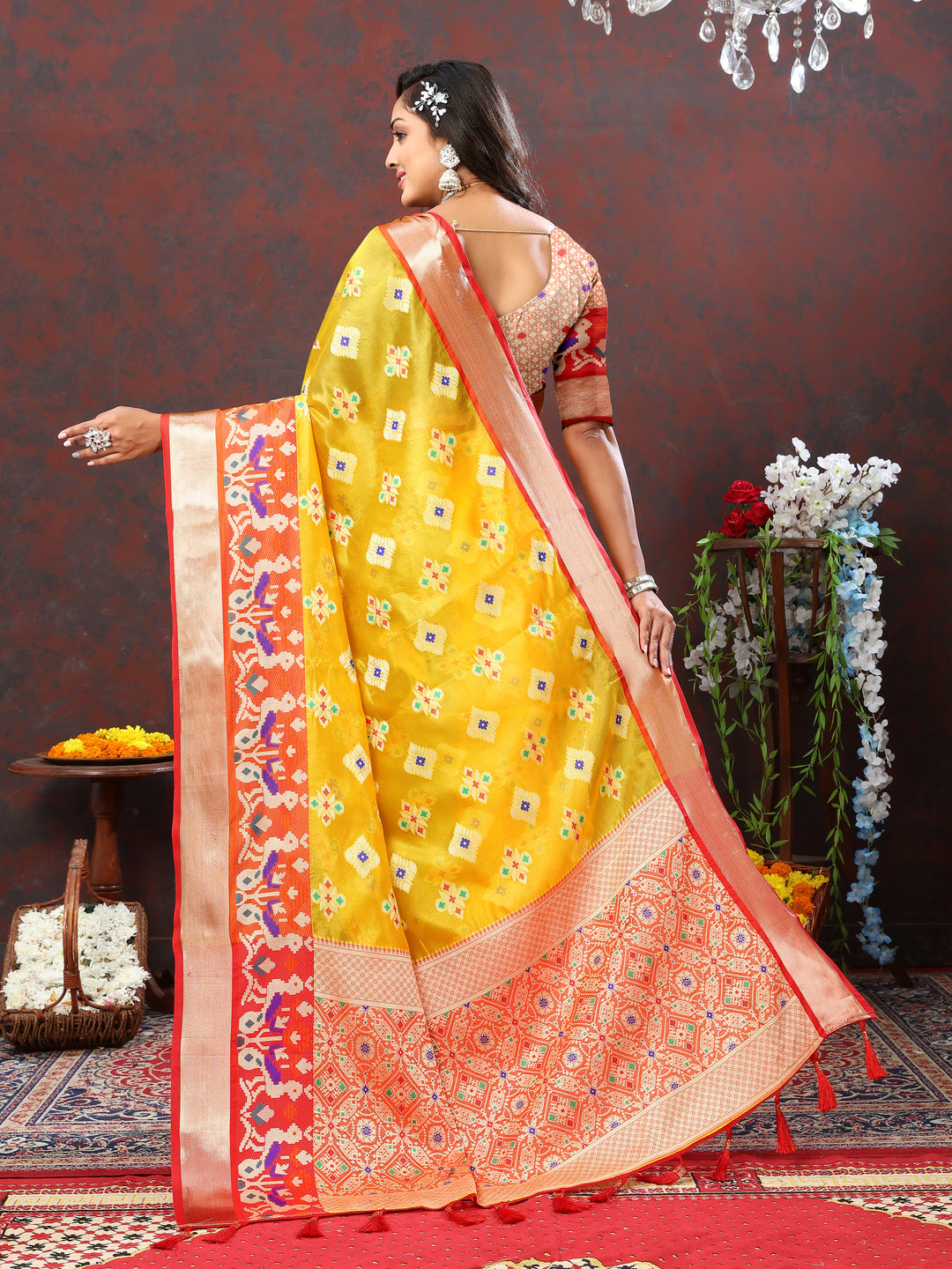 Yellow saree with Meenakari motifs and tassel detailing on the pallu.