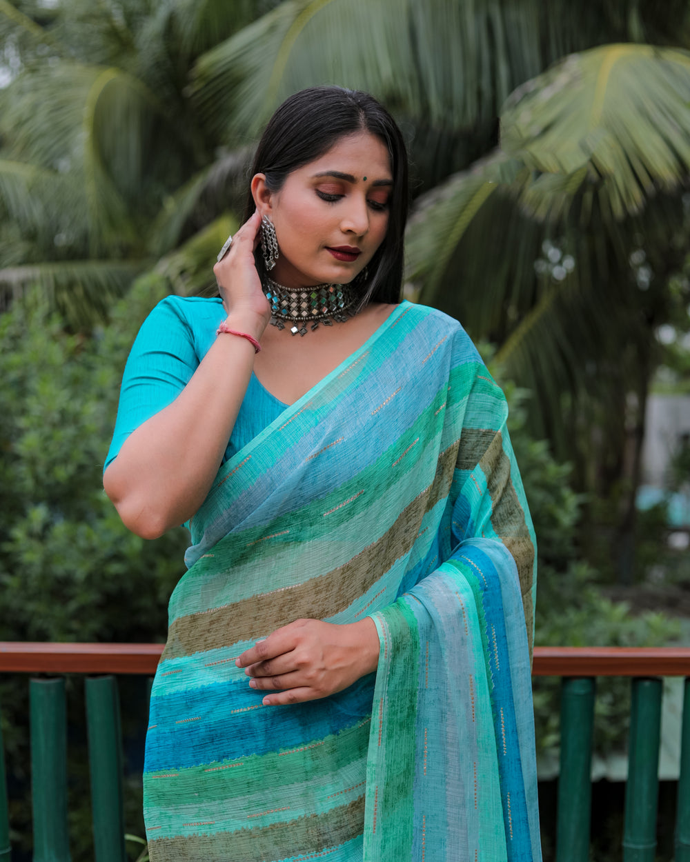 Step into elegance with this sky blue Moss chiffon saree, designed with all-over prints and shimmering gold foil accents for a festive look.