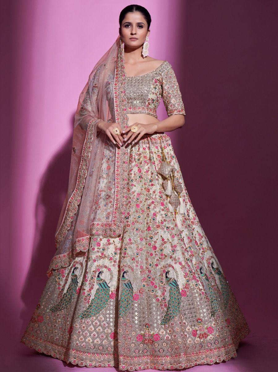 Cream net lehenga choli with sequins embroidery and stonework.