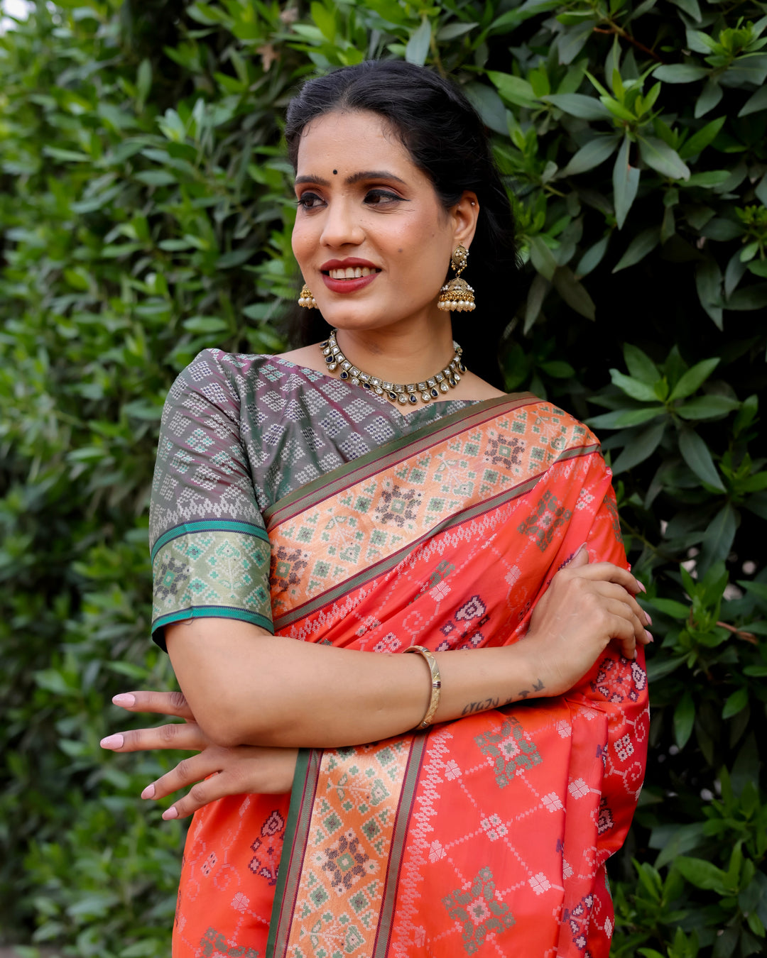 A stunning orange Ikkat Patola silk saree with beautiful Zari weaving borders and a richly designed pallu, perfect for weddings and special events.