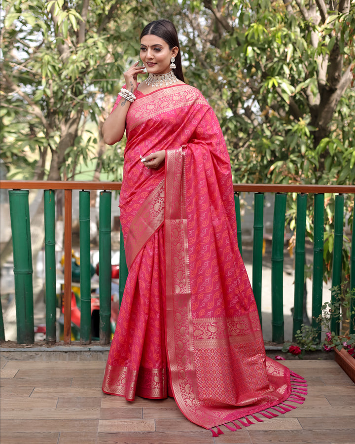 Timeless bright-pink Bandhej Patola silk saree with delicate zari work and Kanchi borders, ideal for cultural gatherings.