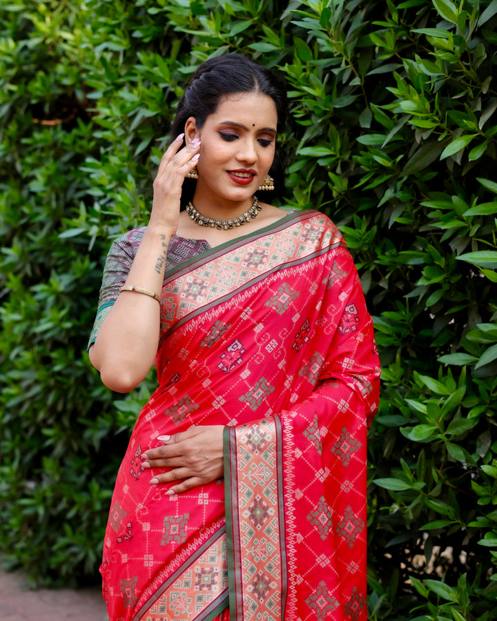 This red Ikkat Patola silk saree offers a vibrant look with beautiful Zari borders and a rich pallu, ideal for special occasions.