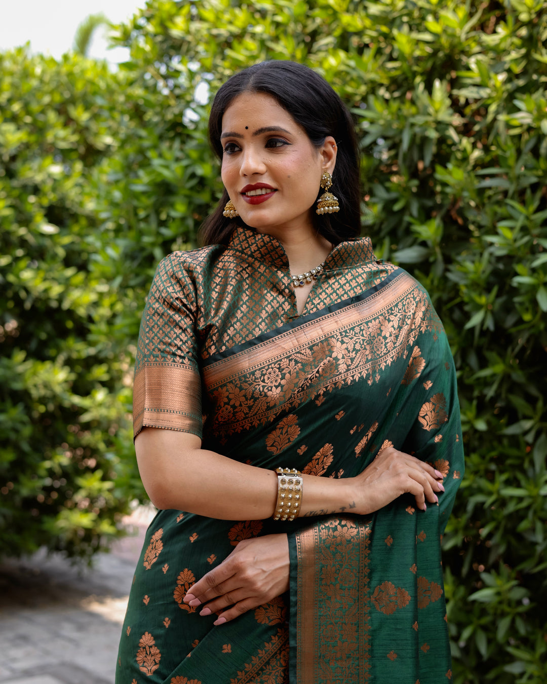 Elegant dark green soft silk saree with copper body and contrast woven borders, perfect for weddings and special gatherings.