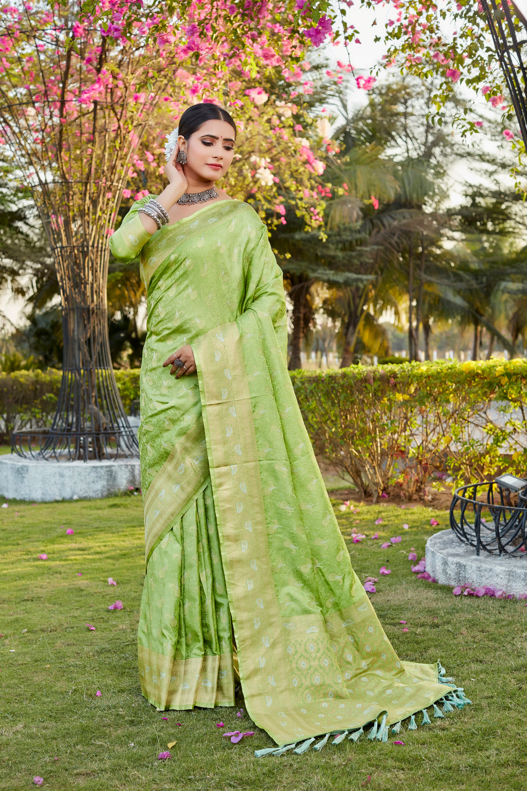 Radiant light-green satin silk Kanjivaram saree with delicate butta work and woven pallu, perfect for a grand event.