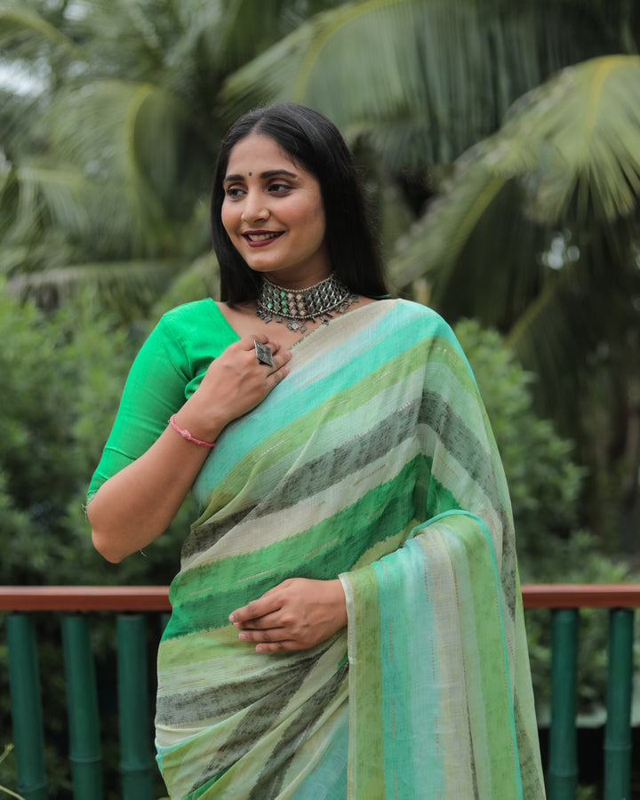 A gorgeous green Moss chiffon saree, featuring intricate gold foil work, perfect for adding sophistication and elegance to your celebrations.