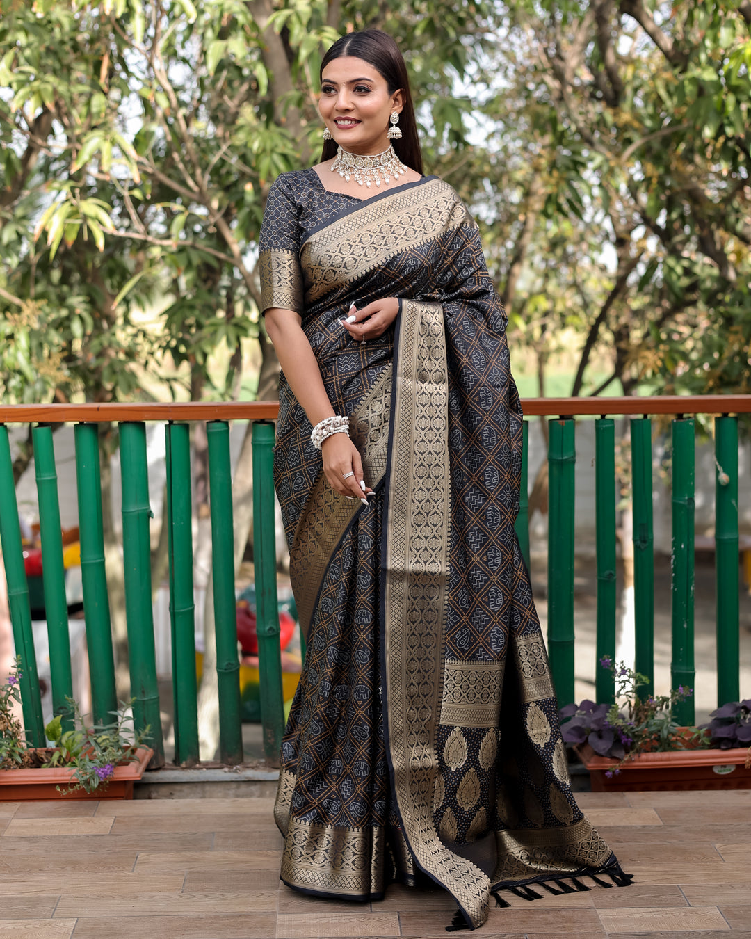 Elegant black saree adorned with Bandhej designs and a stunning contrast zari border, perfect for festive occasions.