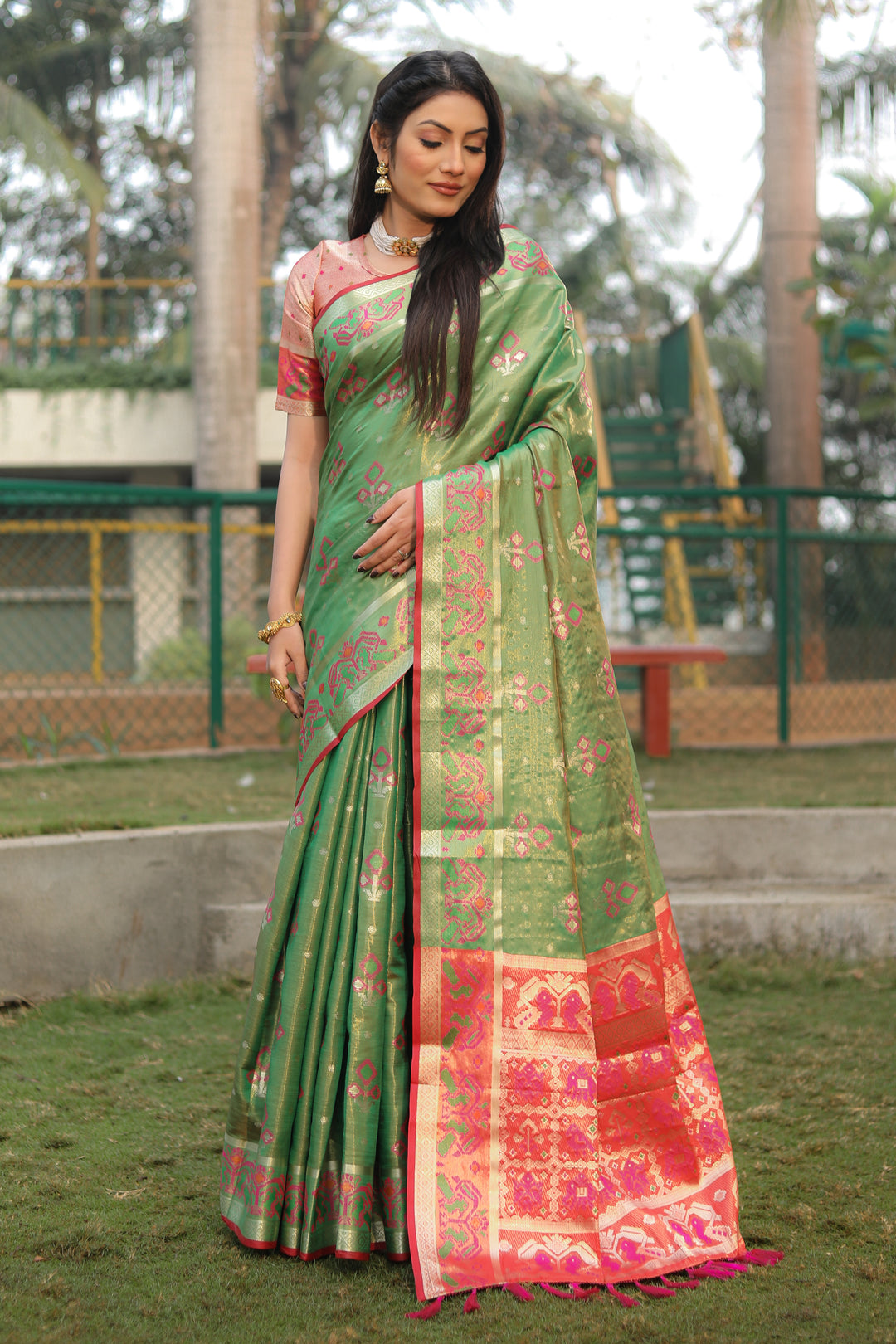 Timeless green organza saree featuring intricate Ikkat Patola print, ideal for weddings and traditional celebrations.