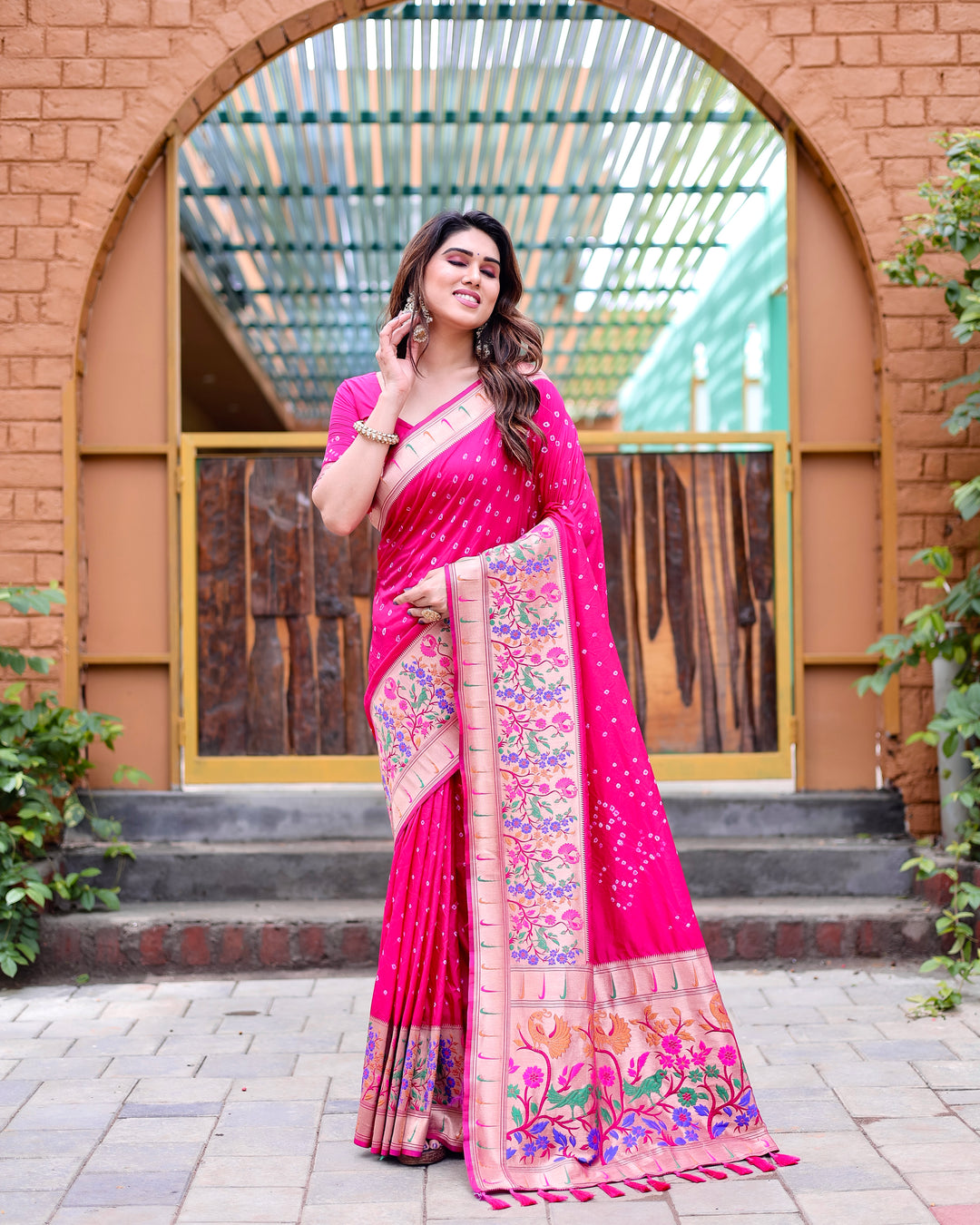 Bright pink Bandhej Paithani silk saree with zari weaving and Paithani pallu adorned with matching tassels, designed for elegance.