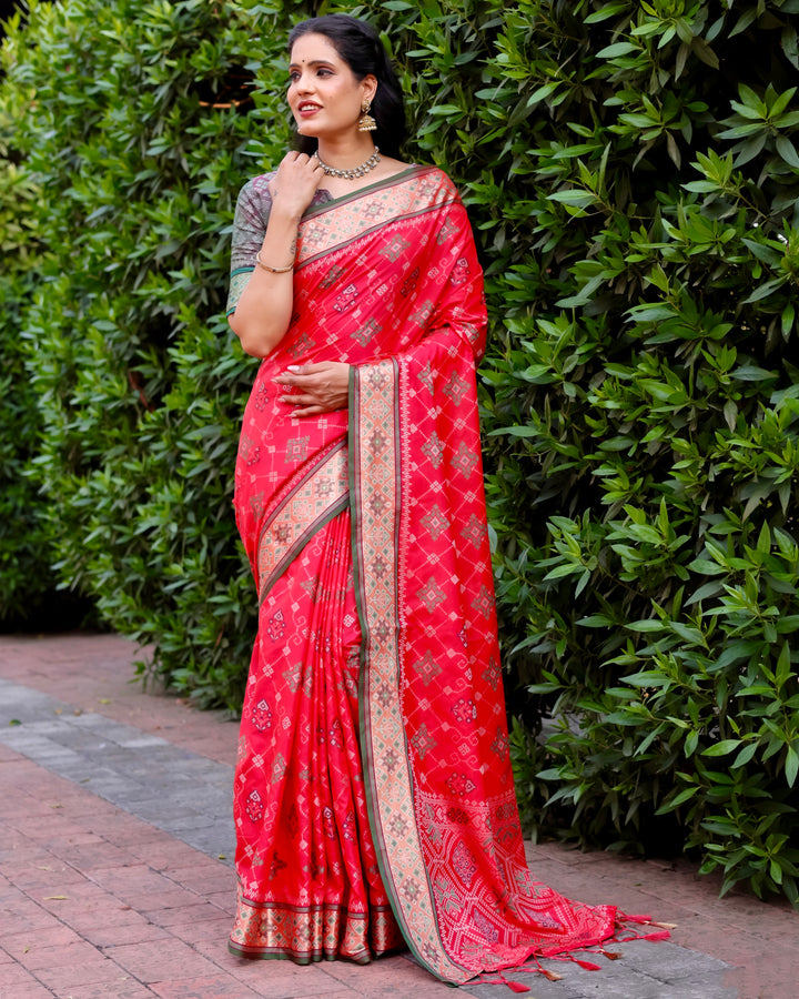 A striking red Ikkat Patola silk saree, designed with intricate Zari weaving and a beautifully woven pallu, ideal for grand occasions.