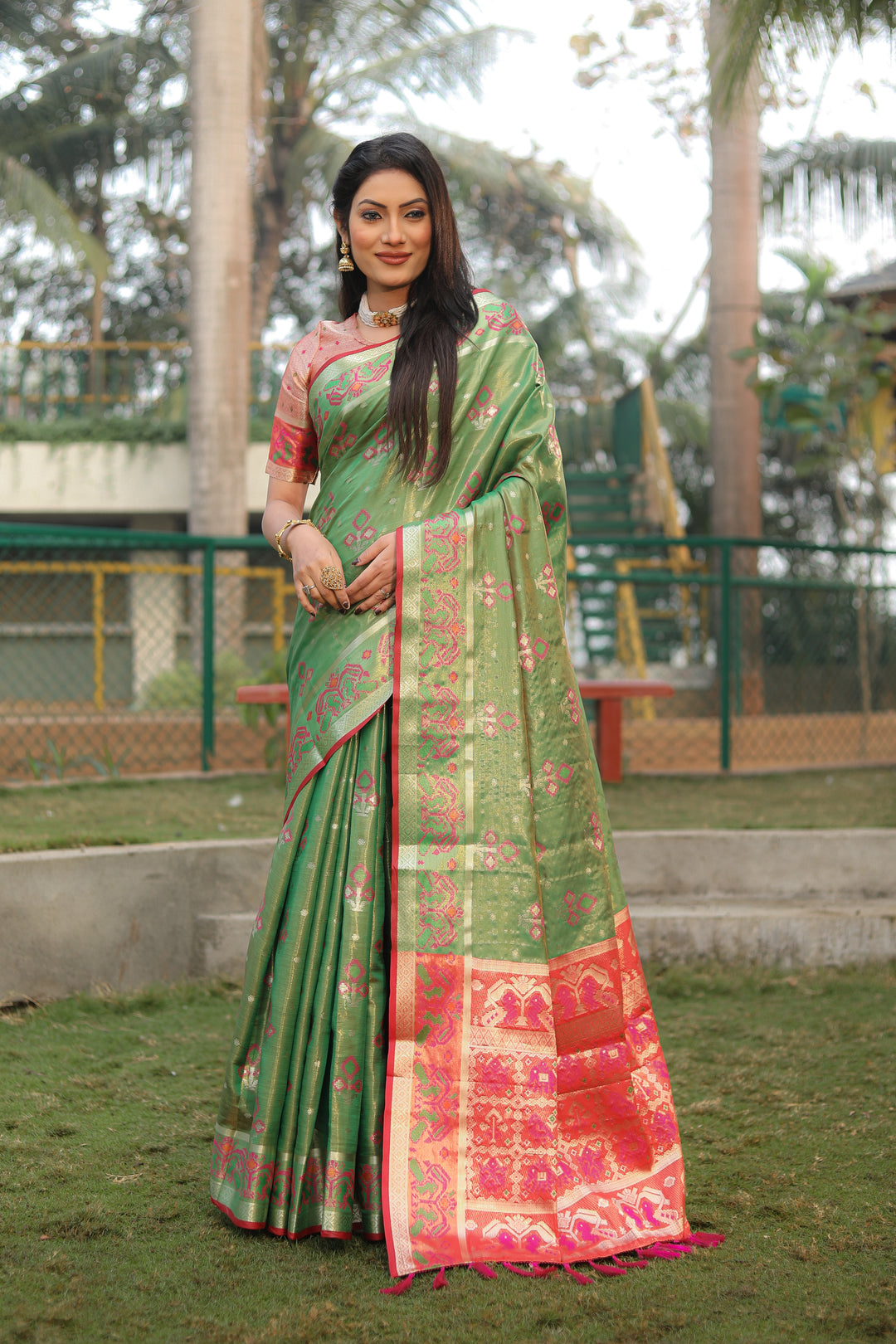 Graceful green organza saree with delicate Ikkat Patola design, perfect for a cultural event.