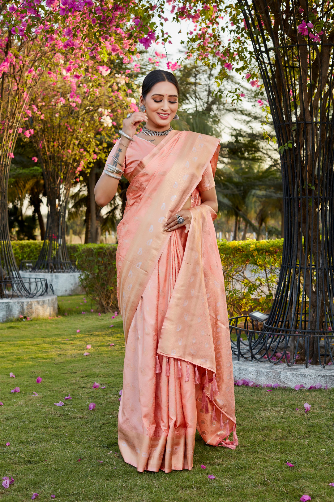 Timeless peach satin silk Kanjivaram saree featuring delicate butta work and woven pallu, ideal for festive occasions.