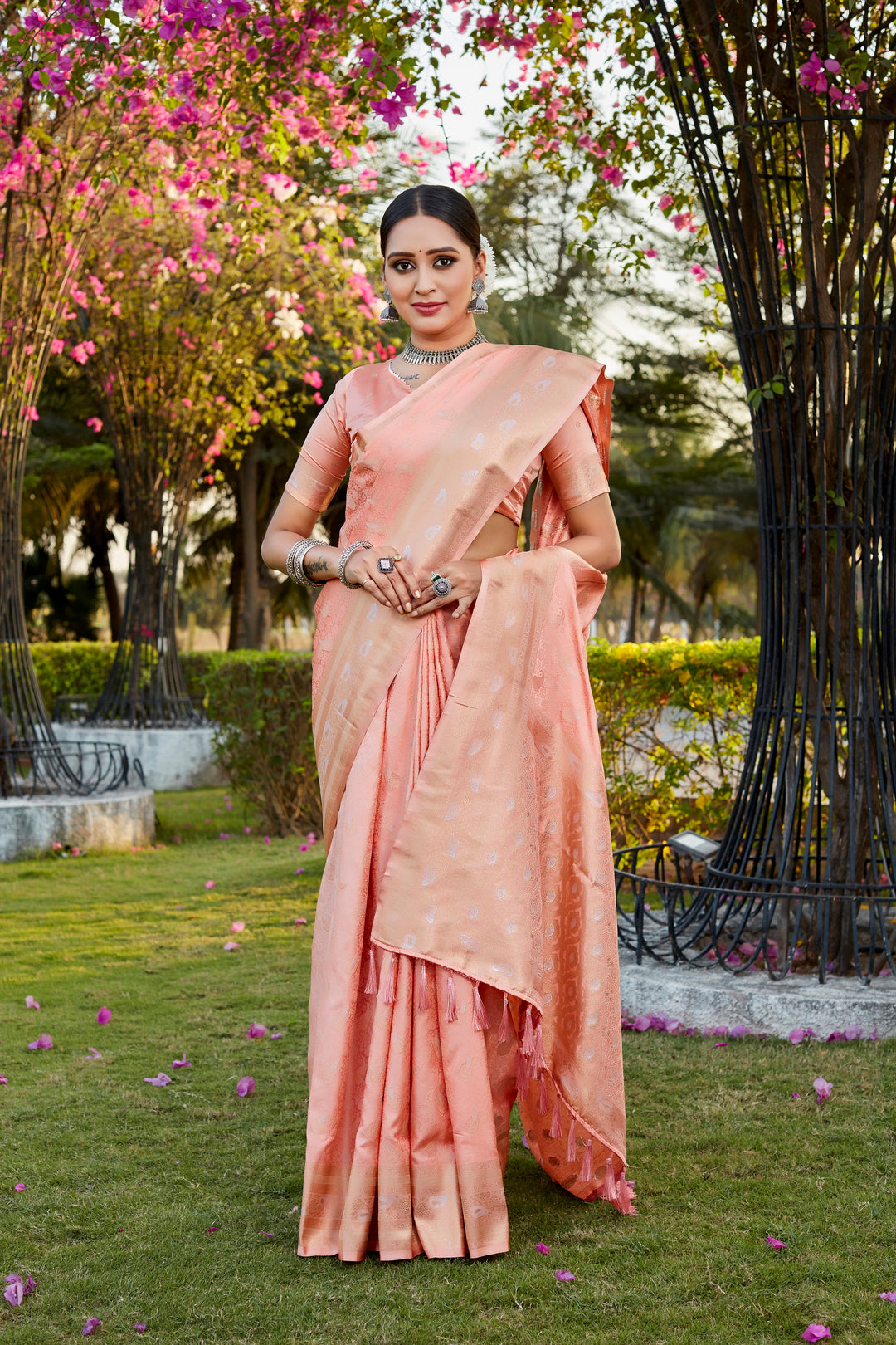 Elegant peach satin silk Kanjivaram saree with intricate butta work and woven pallu, perfect for cultural events.