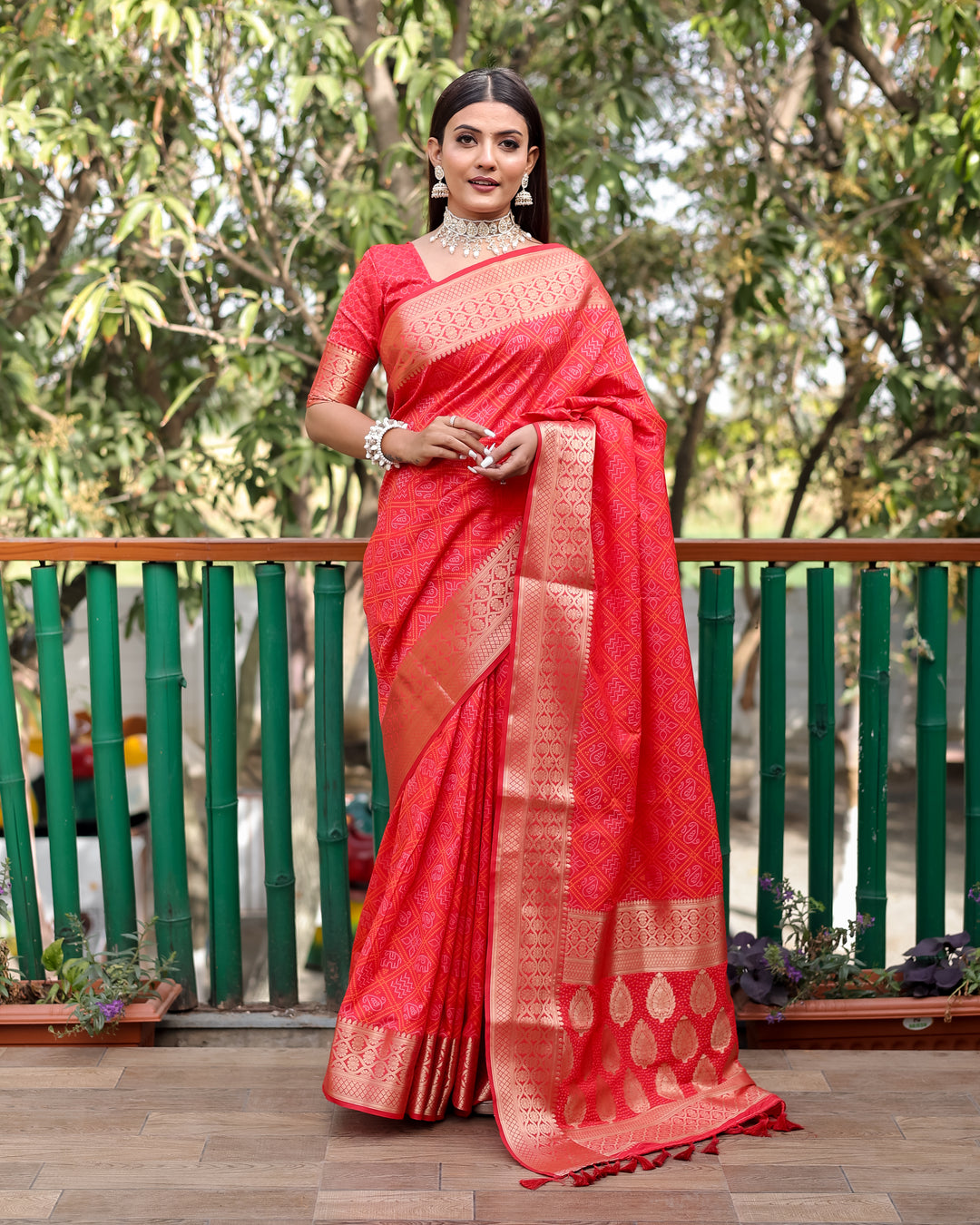 Elegant red saree adorned with intricate Bandhej designs, showcasing traditional craftsmanship in a modern silhouette.