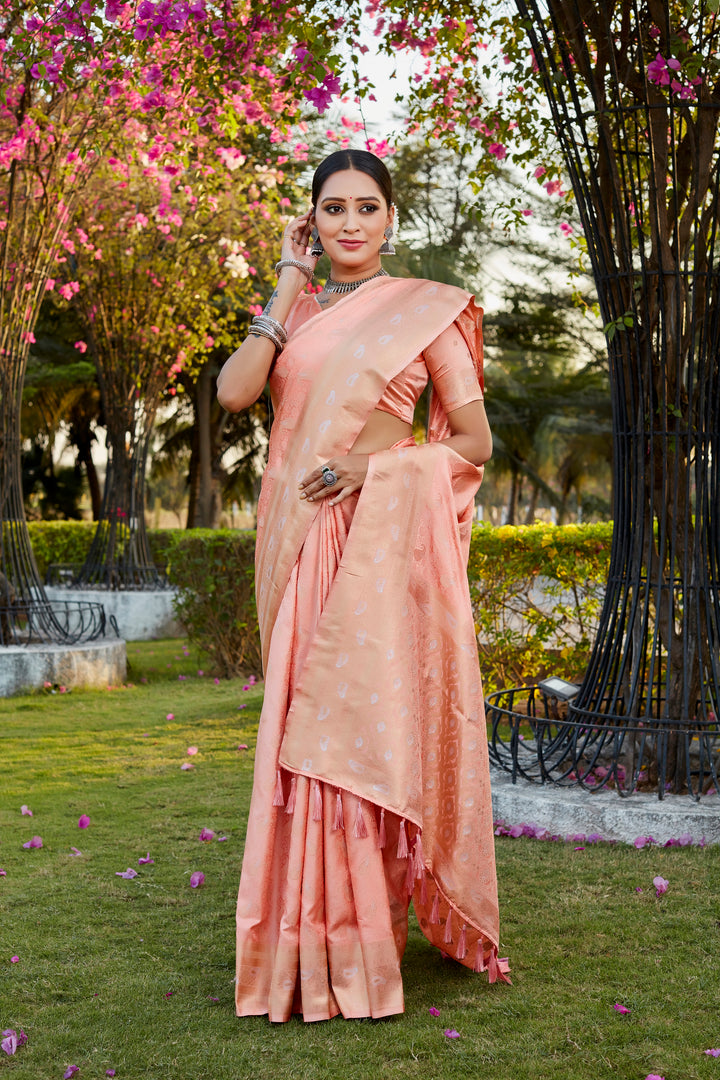 Stunning peach satin silk Kanjivaram saree with delicate butta designs and woven pallu, ideal for traditional wear.