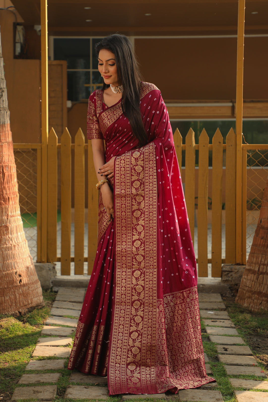 Bright red Bandhej Kanjivaram silk saree with intricate zari weaving and a rich pallu, ideal for festive and traditional celebrations.