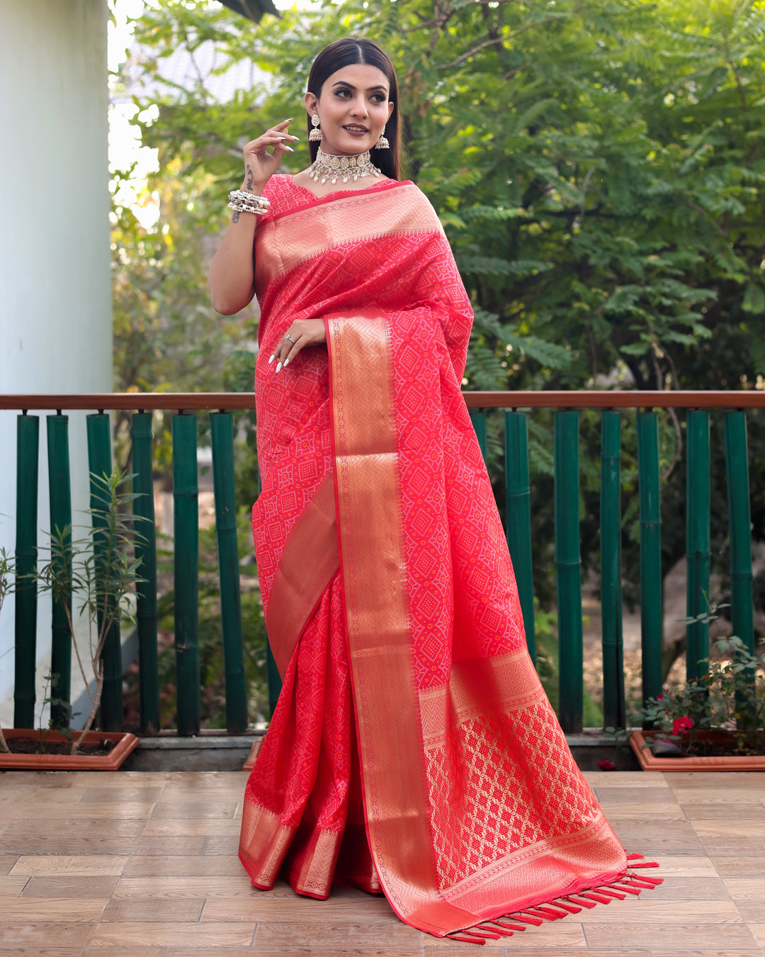 Traditional red Bandhej silk saree with contrast zari borders, embodying sophistication and grace.