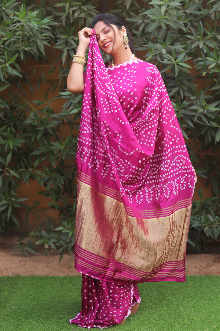 Bright pink pure Bandhej silk saree with intricate Zari pallu and Lagdi Patta, ideal for cultural celebrations.