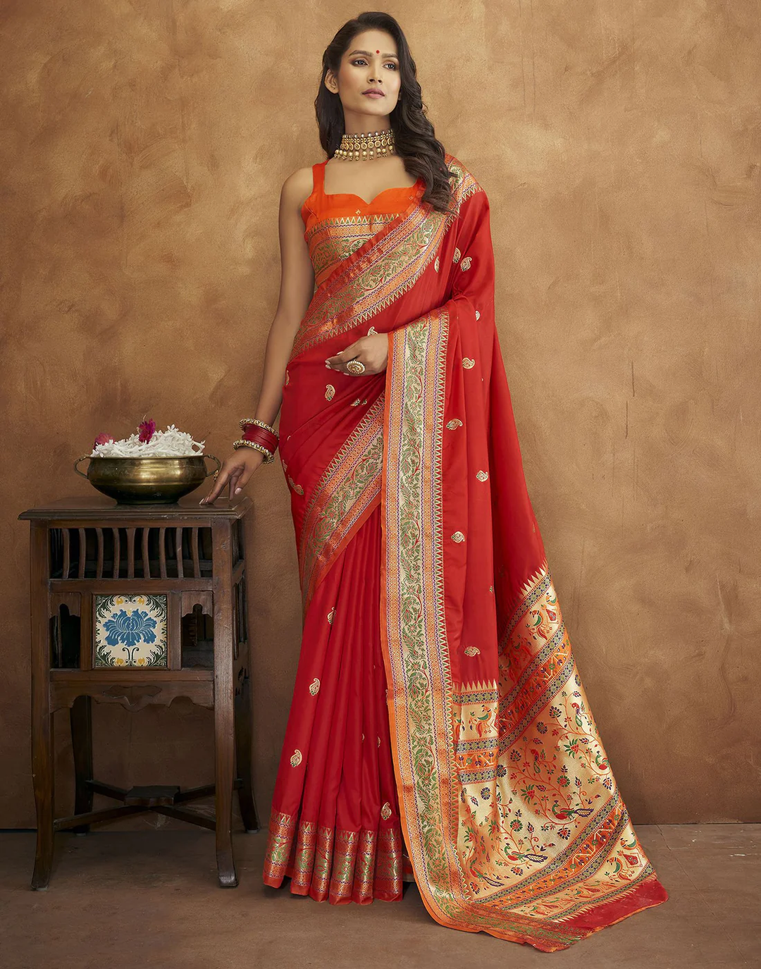 Red Pethani silk saree with gold zari motifs and Meenakari border, ideal for grand celebrations.