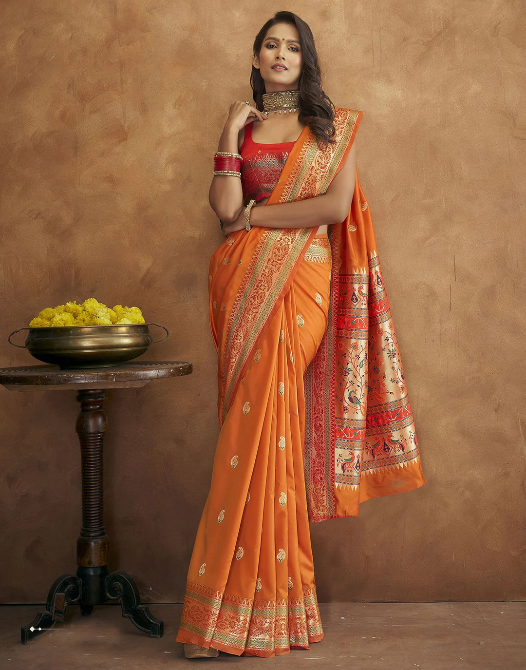 Timeless orange Pethani silk saree with intricate gold zari detailing and Meenakari border for cultural events.