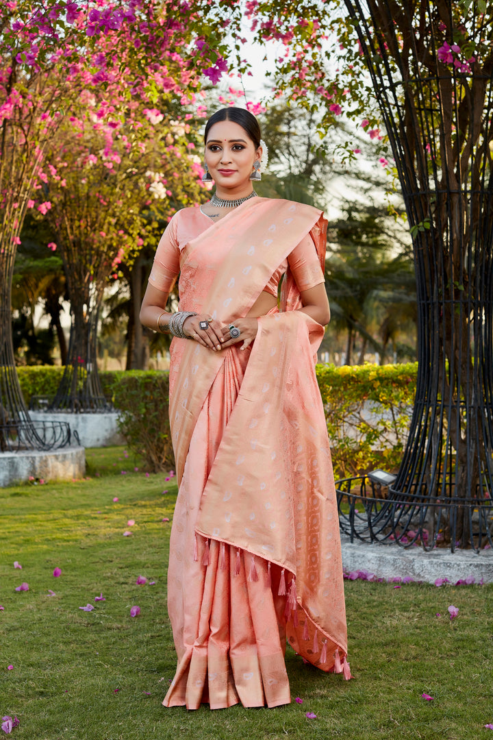 Graceful peach satin silk Kanjivaram saree with beautiful butta work and woven pallu, perfect for celebrations.