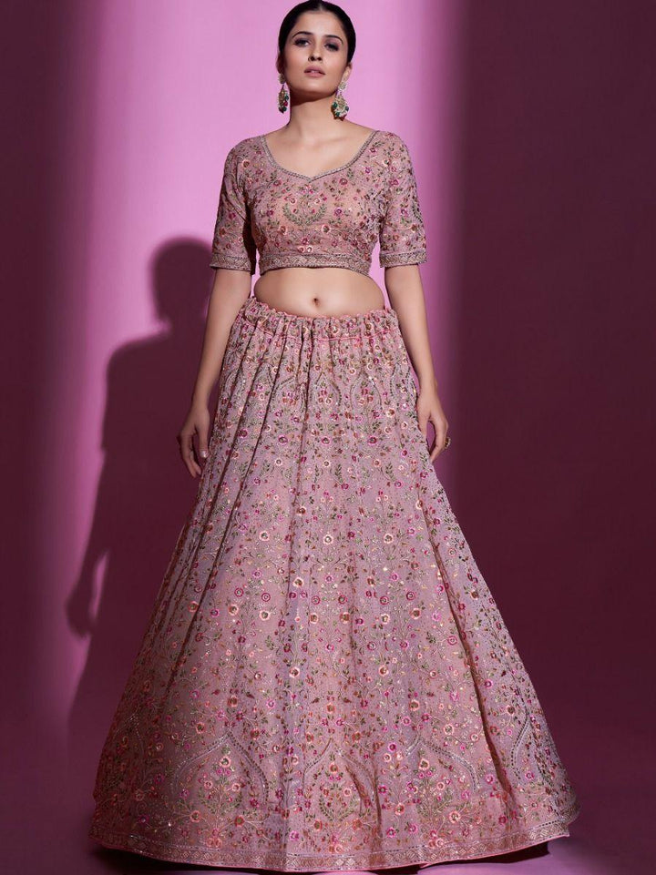 Elegant peach lehenga with heavy embroidery and Swarovski accents.