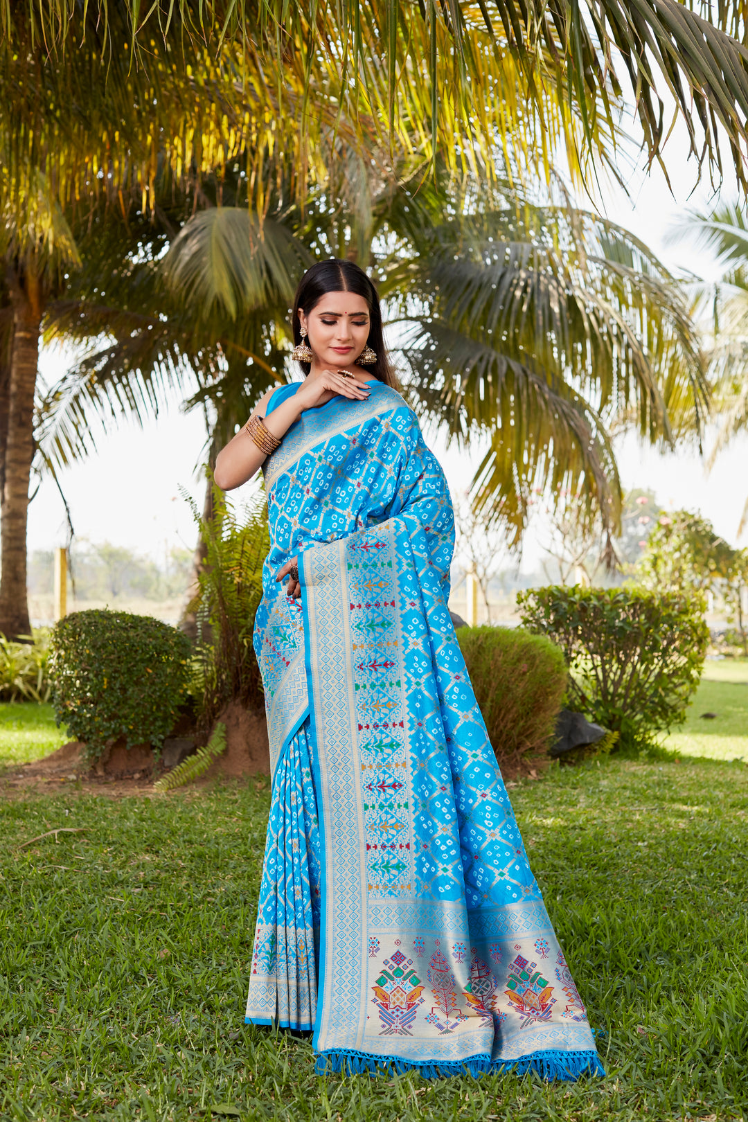 Red Gharchola Bandhej silk saree featuring intricate zari weaving and meenakari borders, perfect for weddings and cultural events.