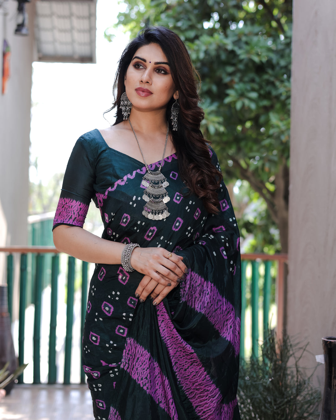 Elegant dark green Bandhej silk saree with exquisite Zari weaving and traditional motifs, designed for celebrations.