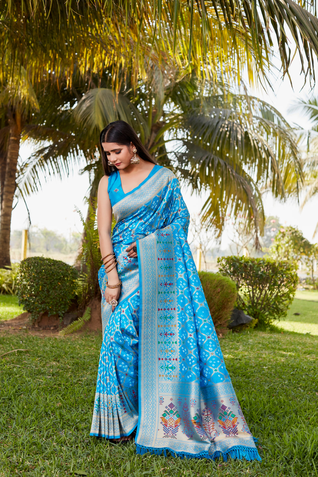 Elegant red Gharchola Bandhej silk saree with intricate zari and meenakari borders, perfect for traditional and wedding events.