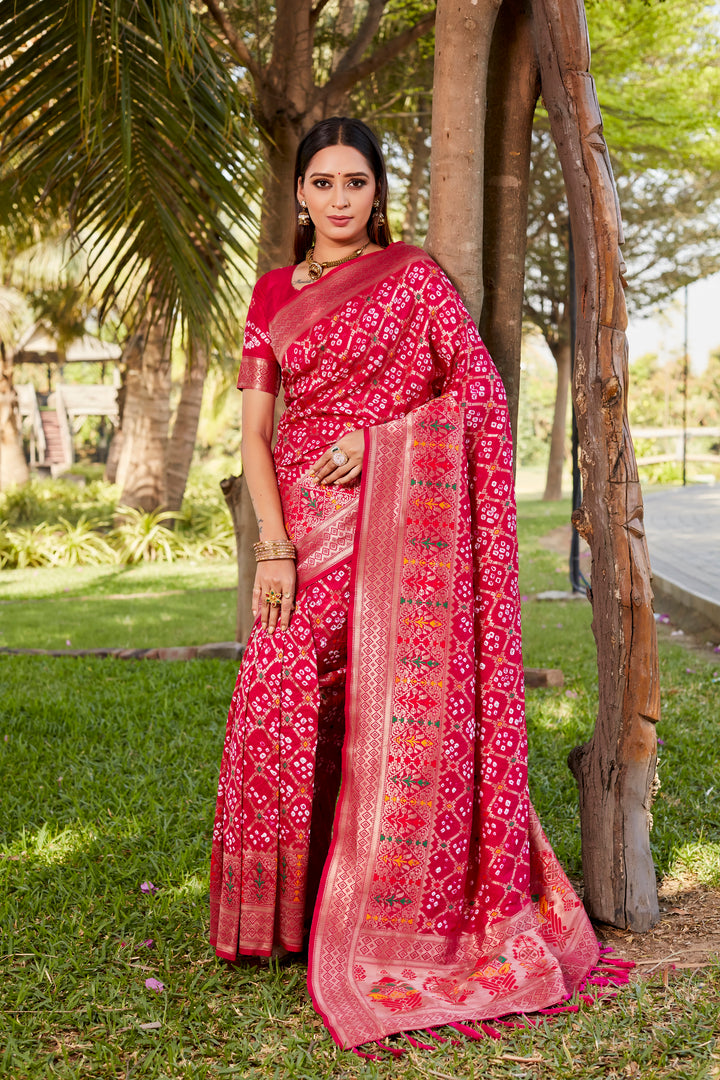 Hot pink Gharchola Bandhej silk saree with intricate zari weaving and meenakari borders, designed for cultural and traditional events.