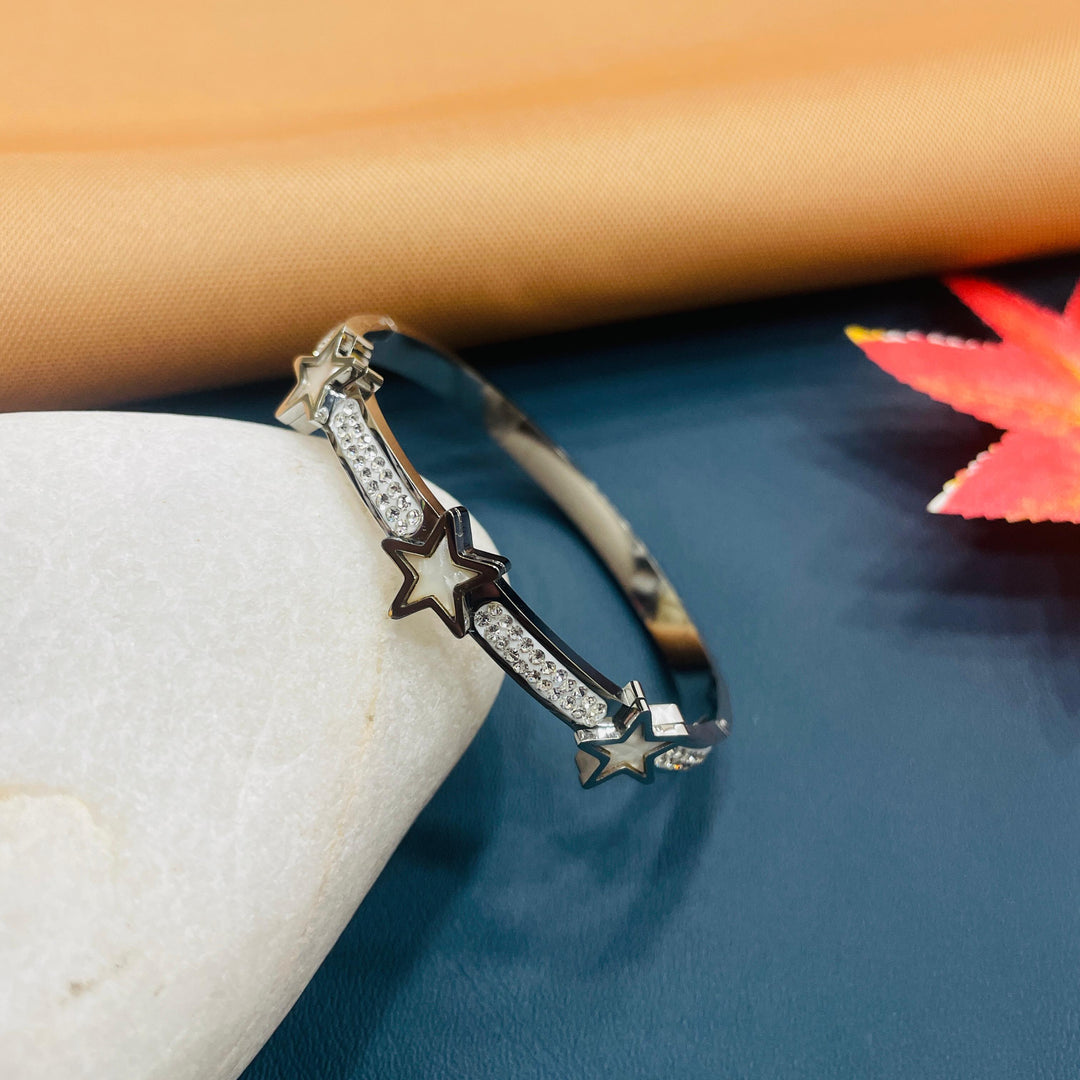 Charming silver bangle with a floral motif, great for summer looks.