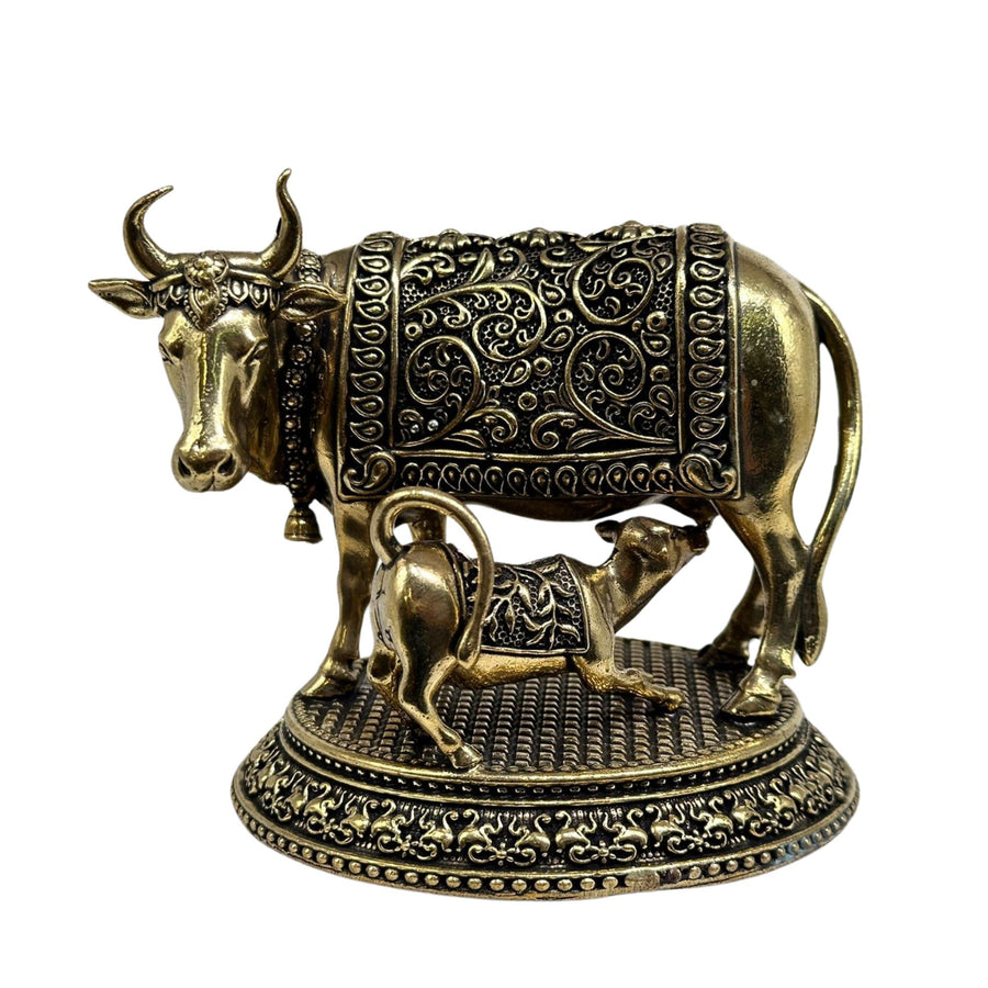 Standing brass cow with calf showpiece, symbolizing nurture and care in home decor.