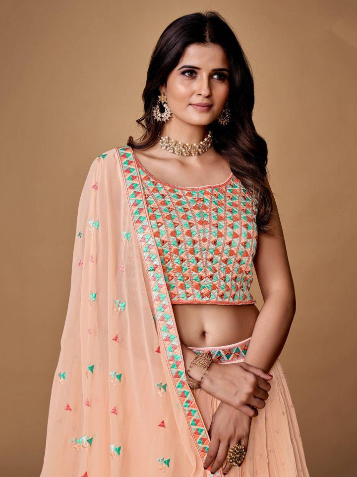 Fully stitched peach lehenga choli with thread embroidery and sequins.