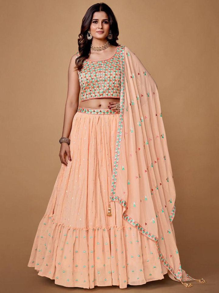 Elegant peach lehenga with ruffle work and matching embroidered choli.