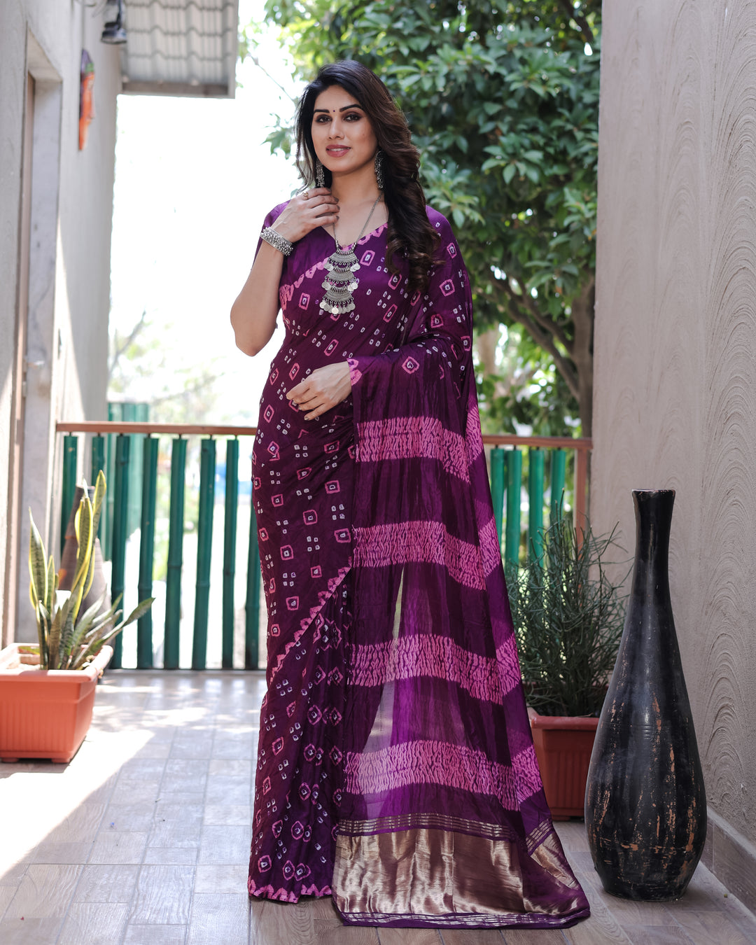 Vibrant purple Bandhej silk saree with intricate Zari work and stunning traditional motifs, perfect for special events.