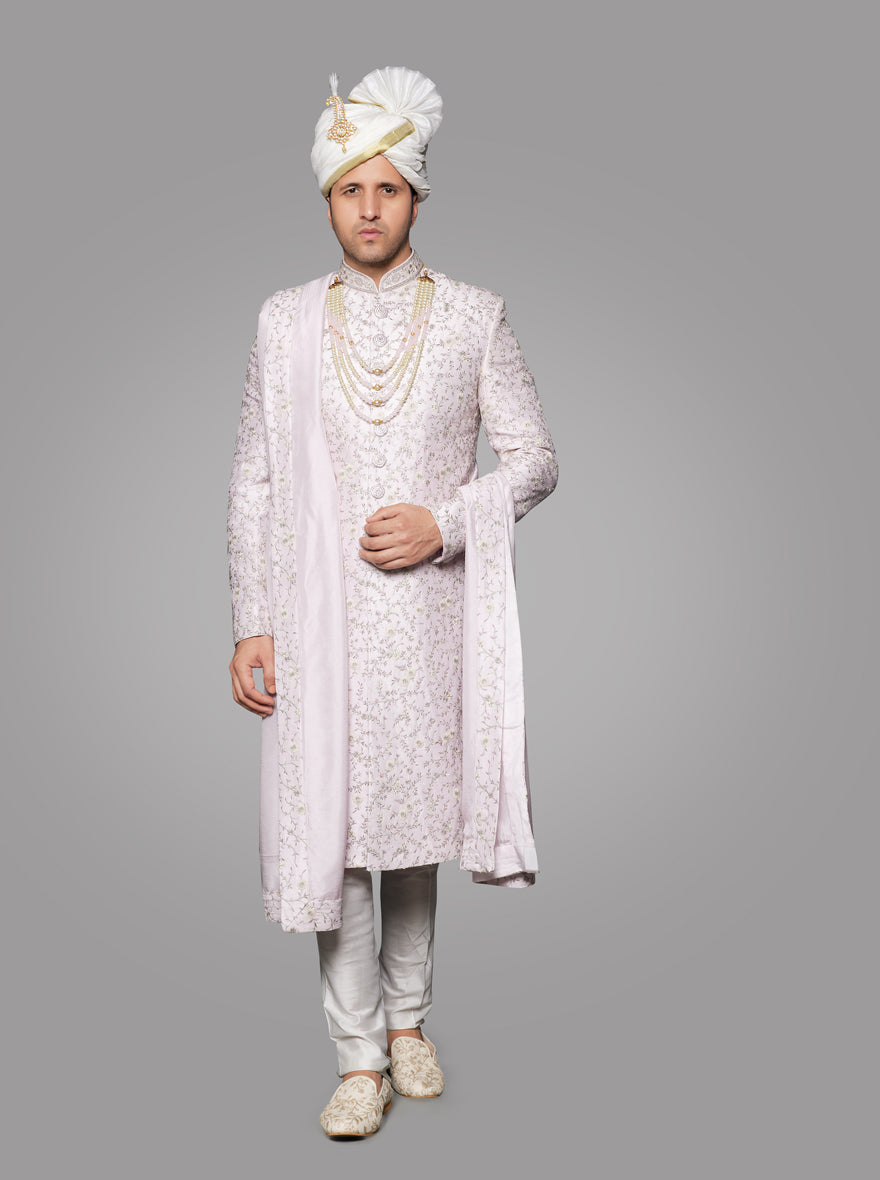 This pink silk sherwani showcases detailed embroidery and button accents for an elegant appearance.