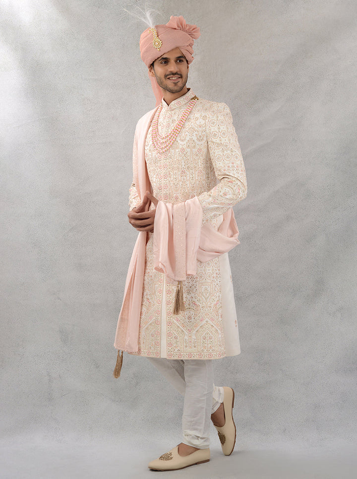 Make a grand entrance in this exquisite cream and peach silk blend sherwani, designed for elegance and comfort at weddings.