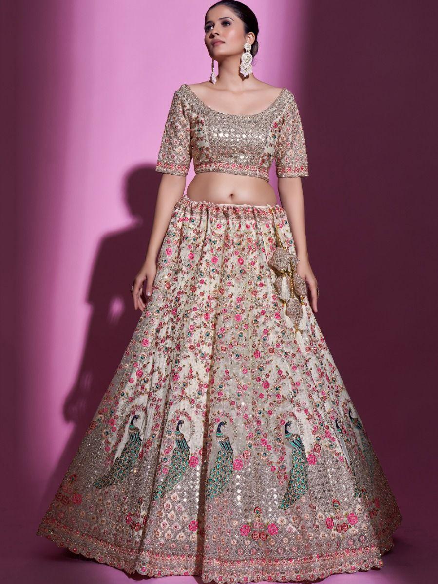 Magnificent cream net lehenga choli with embroidery and stonework.