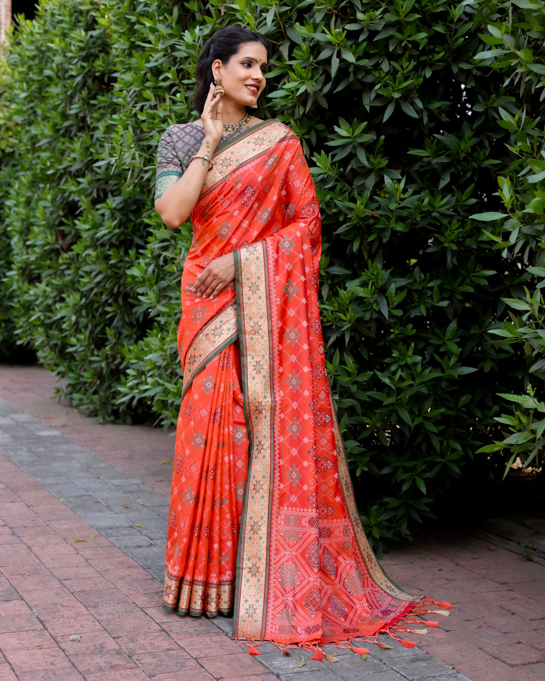 Elevate your festive look with this orange Ikkat Patola silk saree, complete with detailed Zari borders and a beautifully woven pallu.