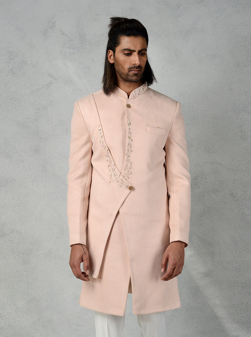 This Peach layered Indo Western with floral hand embroidery and slim-fit trousers is a must-have for modern grooms and stylish men in the USA.