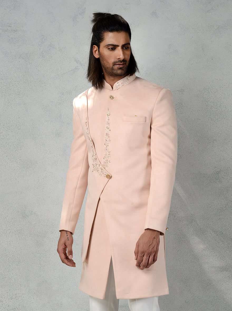 Stand out in this elegant Peach layered Indo Western, designed with floral hand embroidery and slim-fit trousers for a trendy look in the USA.