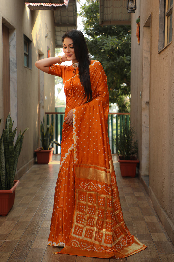 Beautiful orange Bandhej silk saree with original craft and intricate checks pattern.