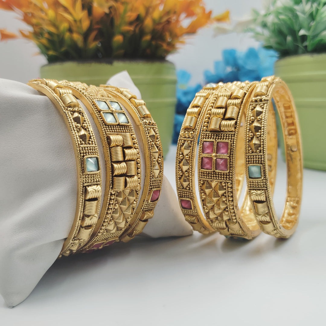 Stylish golden bangles with a twist design for added flair.