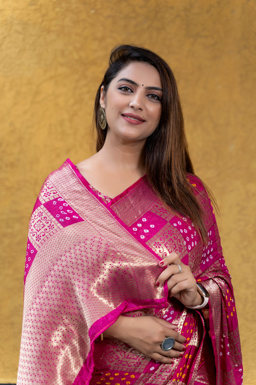 Stunning magenta Bandhej silk saree featuring an eye-catching zari border, ideal for cultural events.