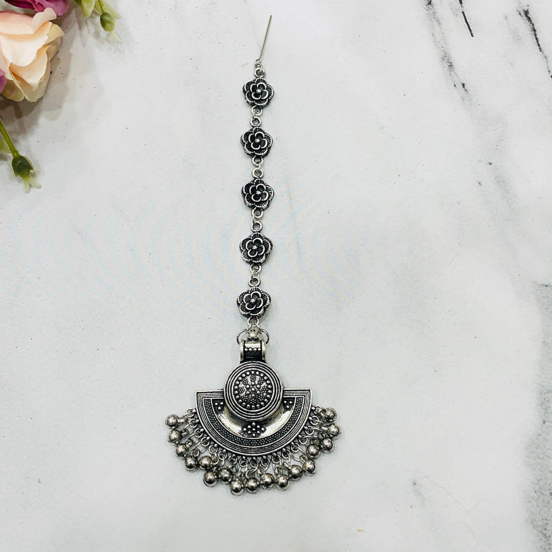 Stylish oxidised maang tikka accessory that complements traditional wedding outfits.