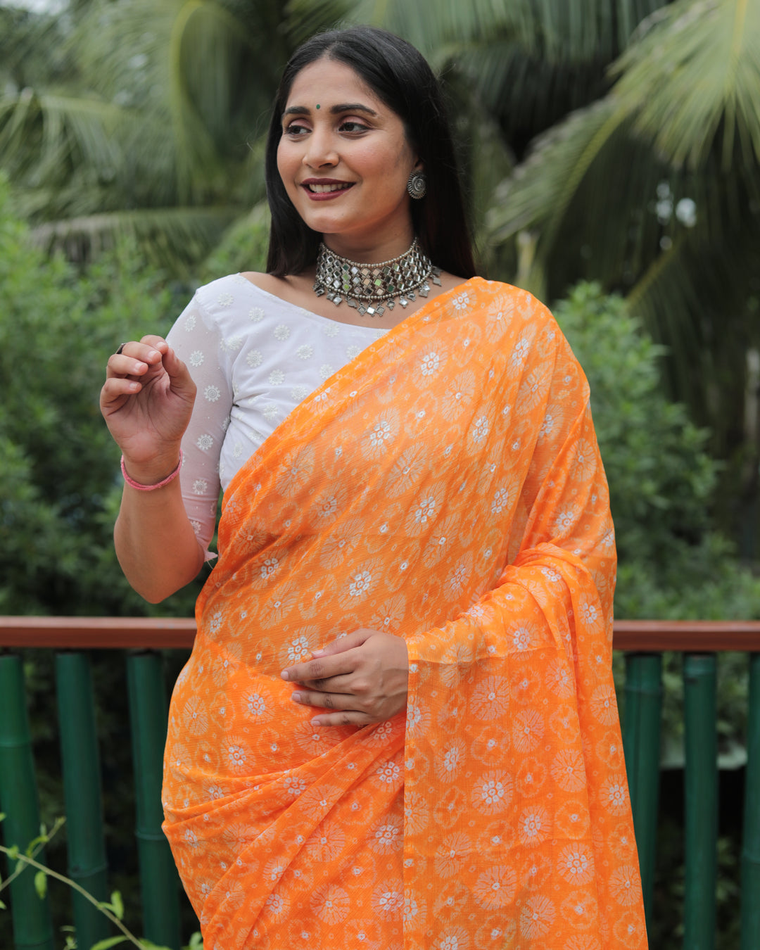 Vibrant orange chiffon saree with luxurious foil detailing, perfect for festive occasions and weddings.