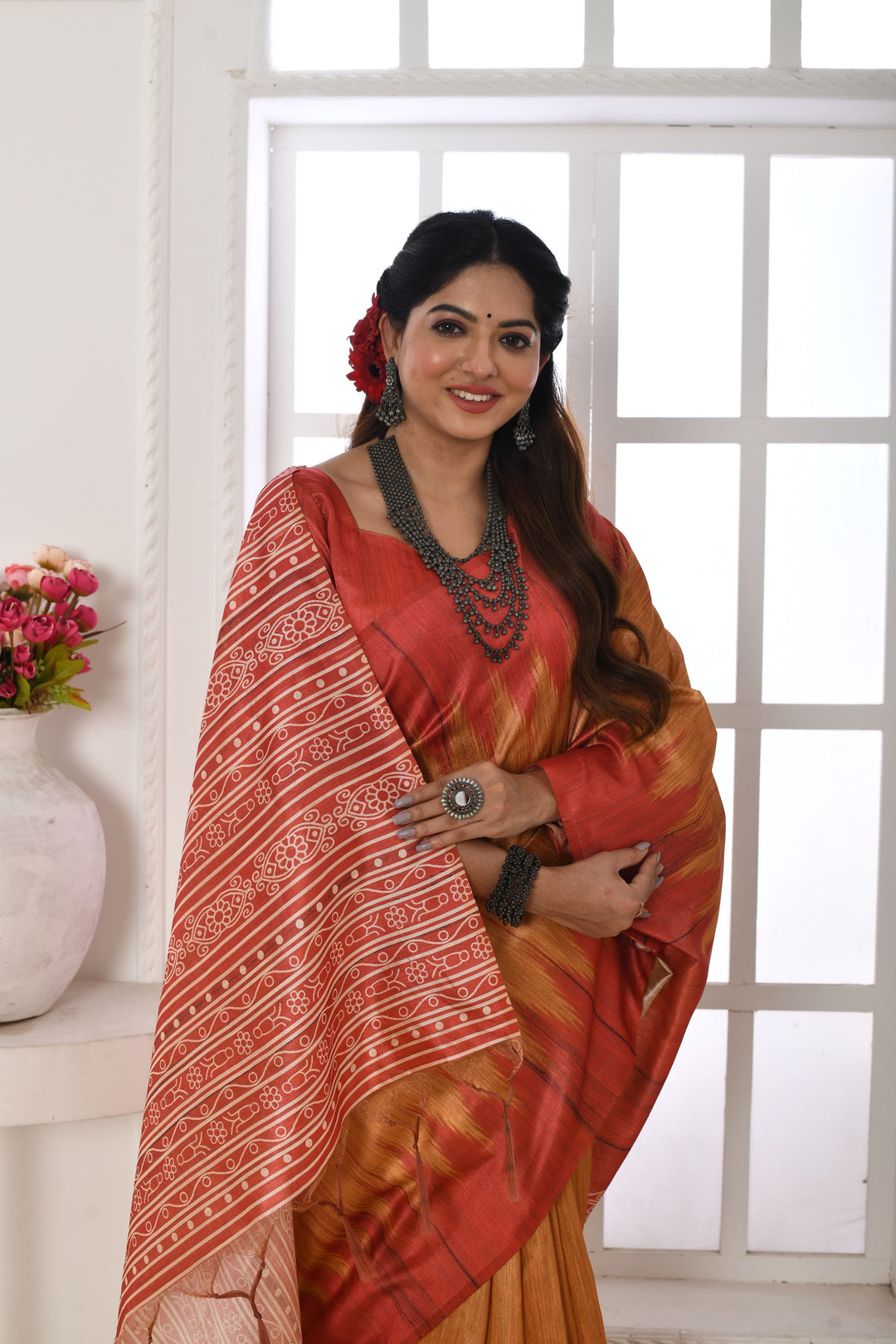 Tussar silk saree with a printed temple border and traditional fabric pattern, ideal for festive occasions.