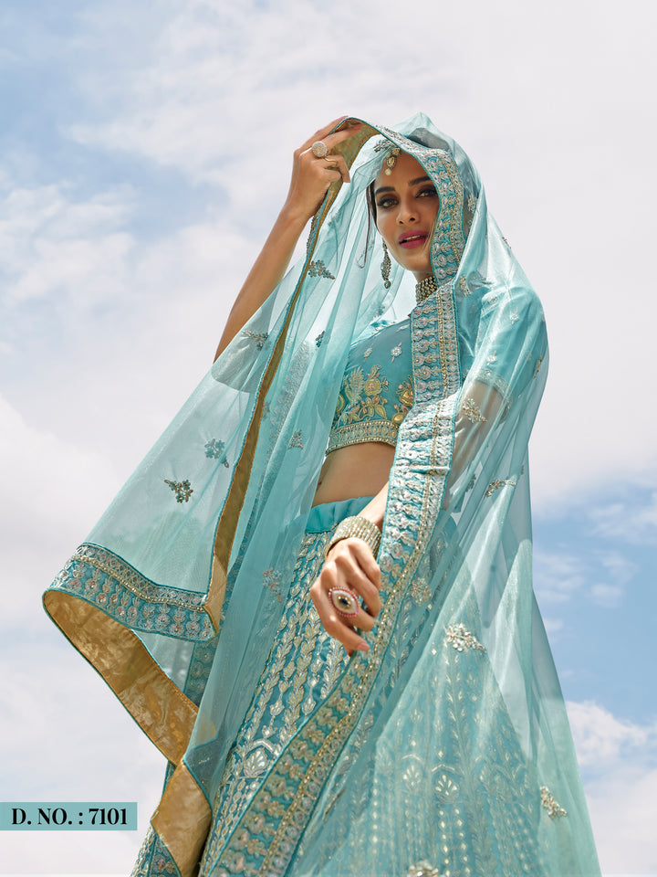 Turquoise organza lehenga choli featuring intricate zari, resham, and gota work; ideal for wedding celebrations and party wear elegance.