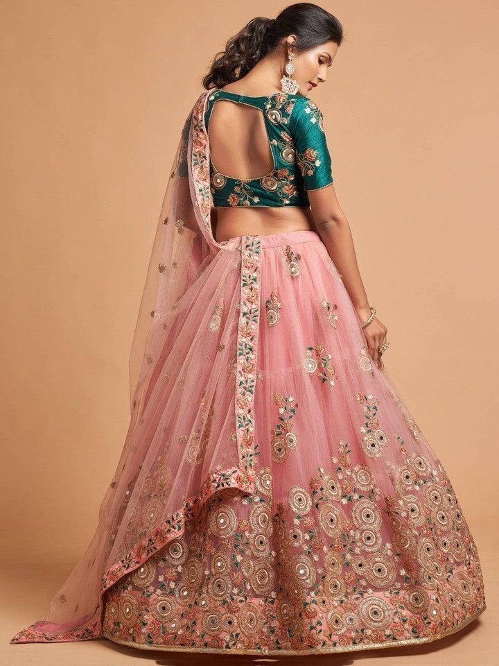 Wedding-ready peach lehenga with mirror and dori embroidery.